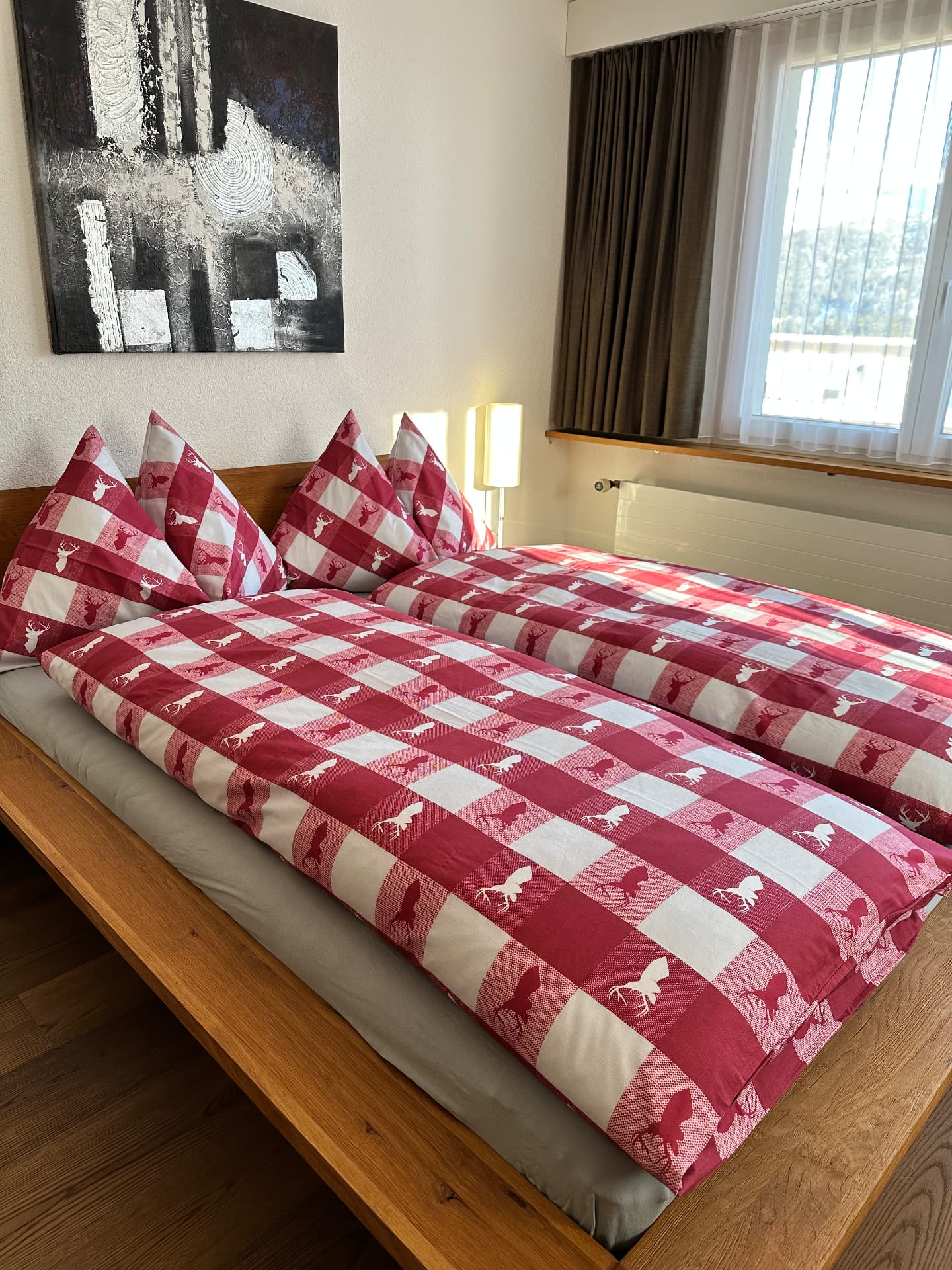 Schlafzimmer mit rot-weiss karierter Bettwäsche